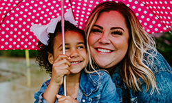 picture of woman and child under umbrella
